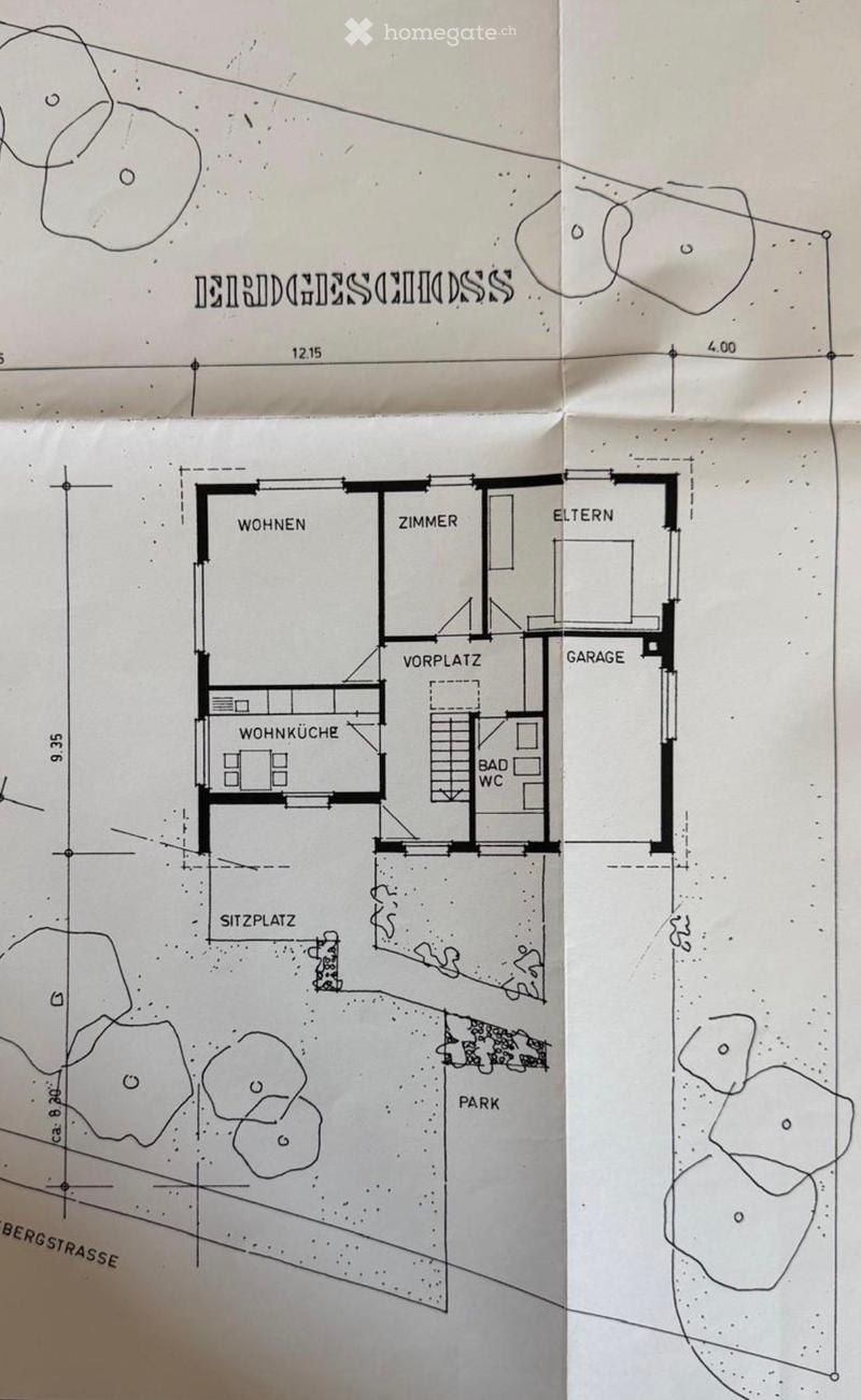 Floor plan showing a house layout with living room, kitchen, bedroom, bathroom, garage, and outdoor seating area.