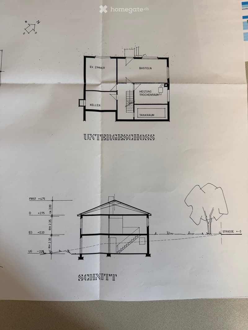 Floor plan of a basement level showing a room labeled "EV. ZIMMER" (possible room), a "BASTELN" (craft room), a "HEIZUNG TROCKENRAUM" (heating/dry room), a "TANKRAUM" (tank room), and a "KELLER" (basement).