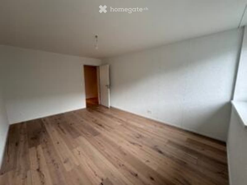 Completely empty room with white walls and wooden floor. No furniture or equipment.