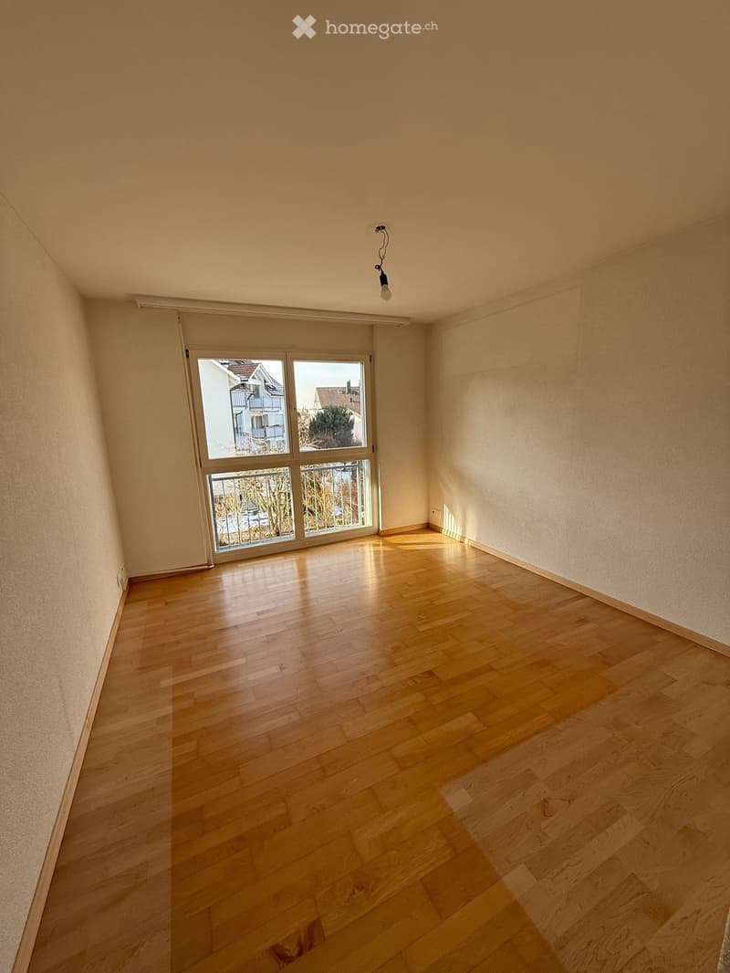 spacious room, hardwood floor, sliding glass doors, balcony, neutral walls