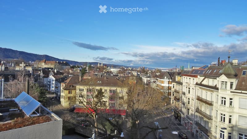 A panoramic view of a cityscape with a mix of residential and commercial buildings, featuring a variety of architectural styles, including traditional and modern structures. The scene includes a prominent green dome on one of the buildings, surrounded by
