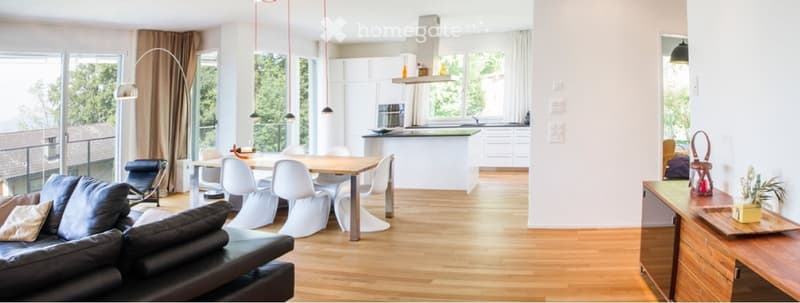 Modern open-plan living and dining area with a leather sofa, coffee table, dining table with chairs, kitchen island, and pendant lights.