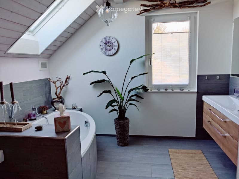 Bathroom with bathtub, sink, mirror, plant, and window with blinds