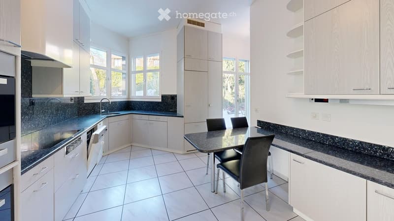 modern kitchen with white cabinets, granite countertops, stainless steel appliances, dining table, black chairs, windows
