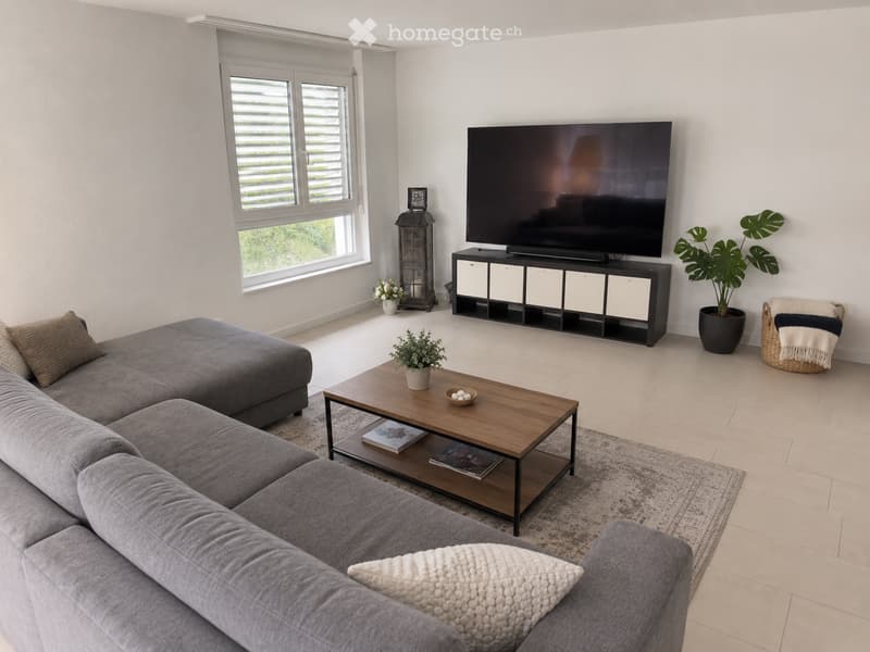 Modern living room with a grey sectional sofa, wooden coffee table, flat-screen TV on a black stand, and decorative plants.
