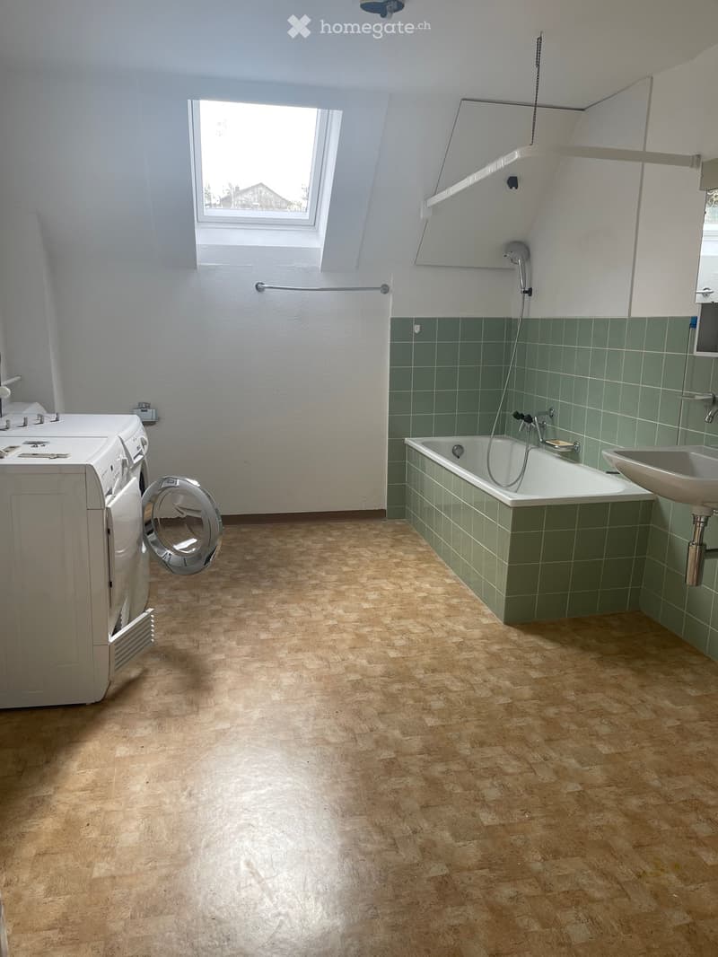 bathroom with bathtub, green tiles, washing machine, sink, shower