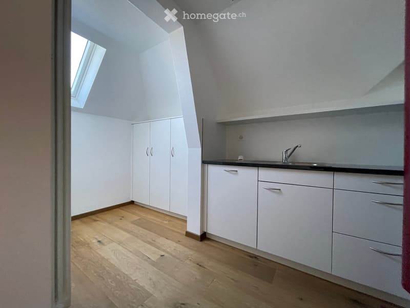 wooden floor, white cabinets, kitchen sink, skylight, spacious