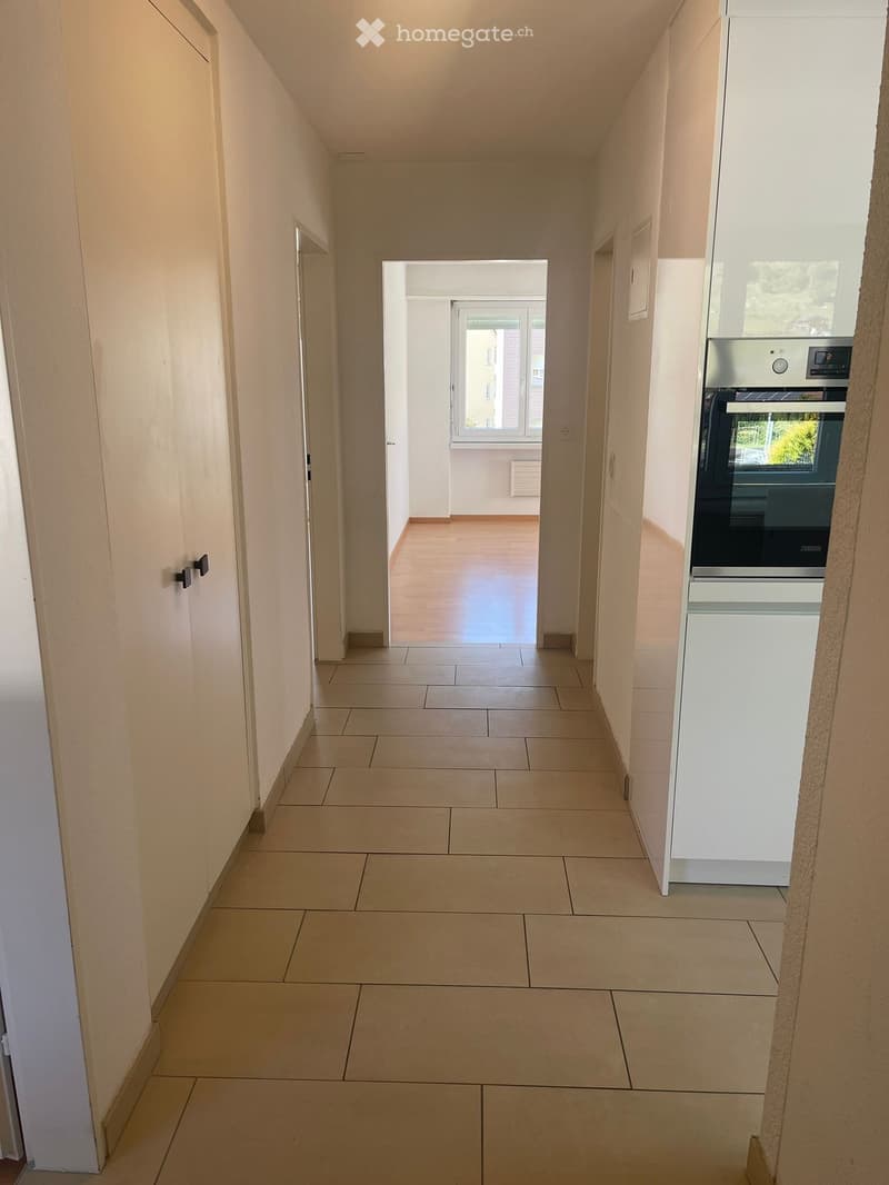 empty hallway, tiled floor, built-in cabinets, open window, oven, dishwasher, washing machine