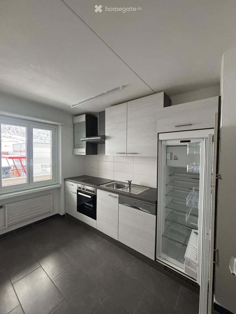 modern kitchen, white cabinetry, black countertop, stove, sink, dishwasher, refrigerator