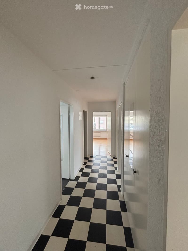 Empty corridor with white walls, black and white checkered floor