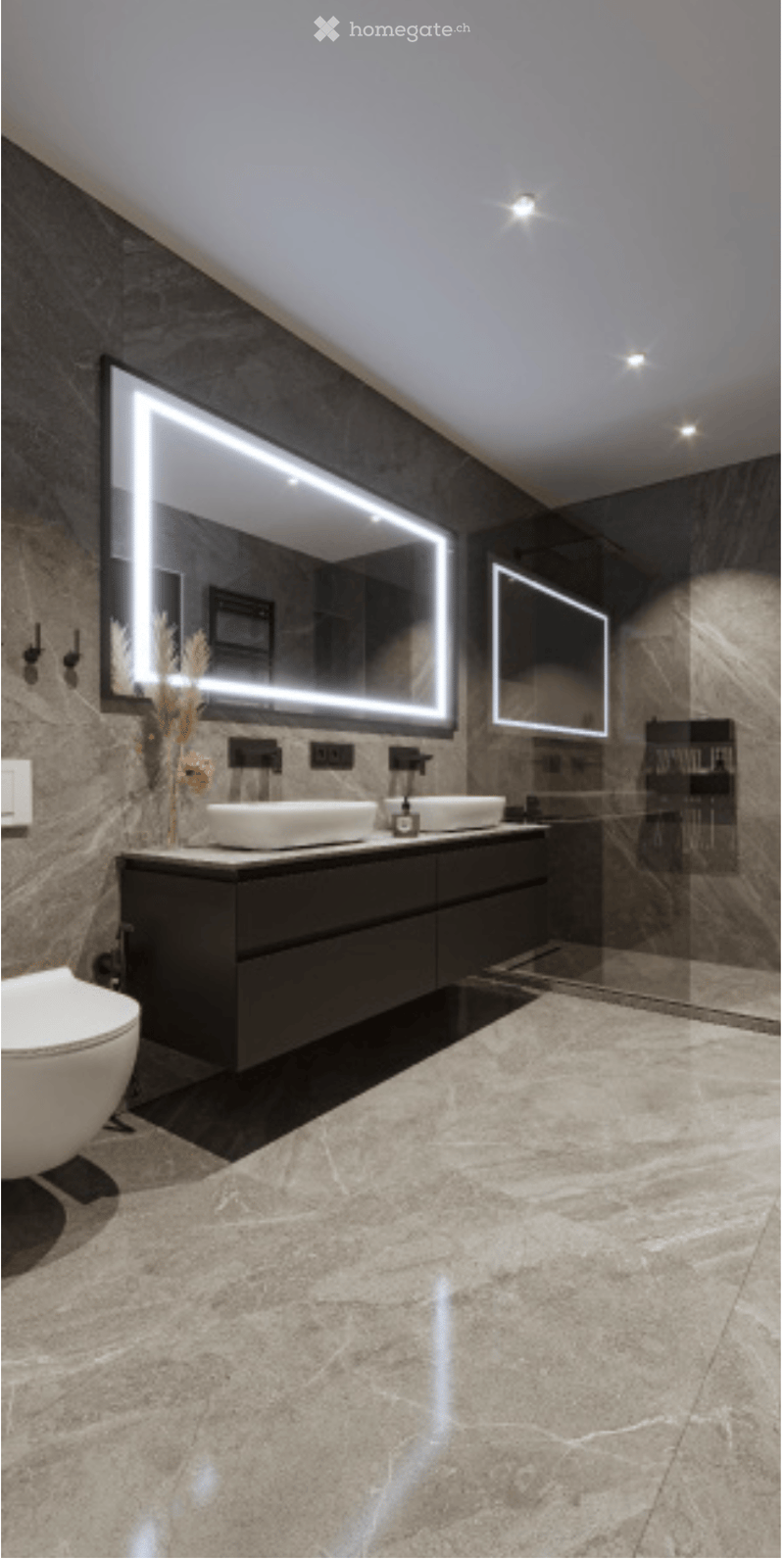 Modern bathroom with dark marble walls, large illuminated mirrors, double sinks, and a sleek black vanity cabinet.