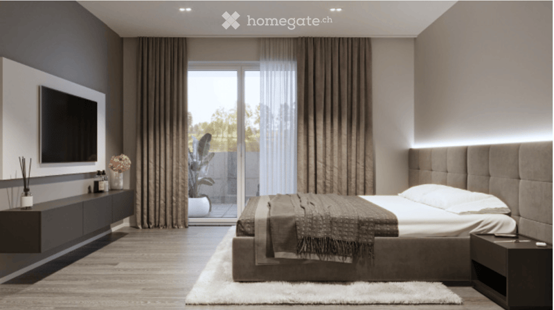 Modern bedroom with a large bed, headboard, nightstand, and a TV mounted on the wall. The room features large windows with curtains, a potted plant, and a sleek black side table with decorative items.
