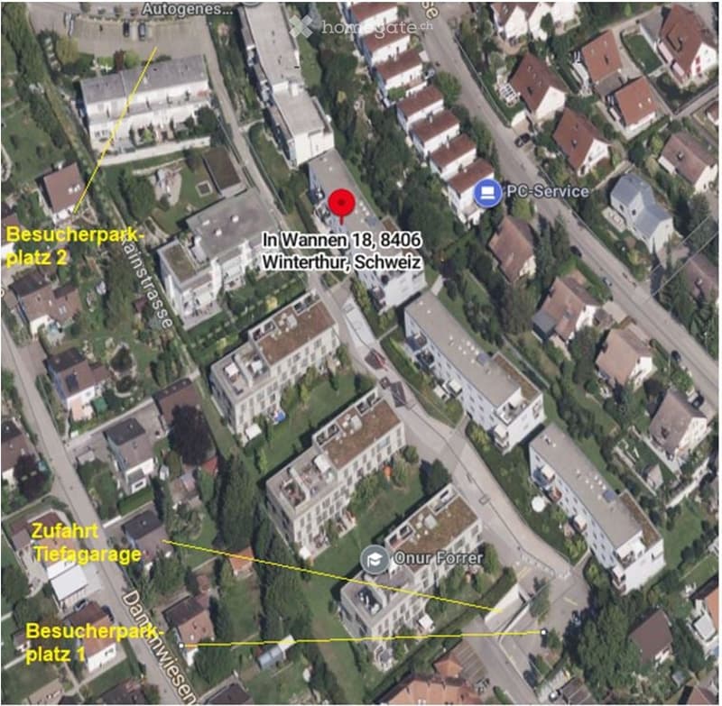 Aerial view of a residential area showing multiple buildings, streets, and labeled points of interest including a garage access point.