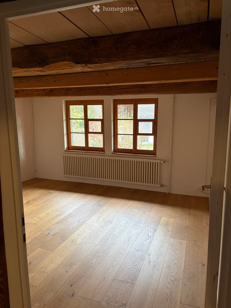 bare room with wooden floor, white walls, wooden ceiling, large windows, radiator