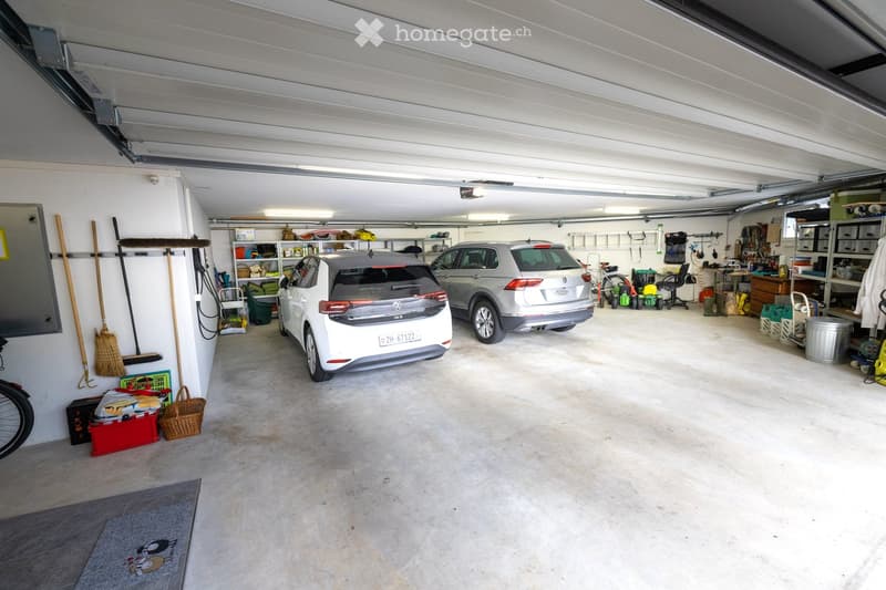 {"type": "Garage", "objects": [], "visible_features": ["Garage"], "description": "Clean, well-lit garage with two parked cars, storage shelves, and various tools and equipment neatly arranged."}