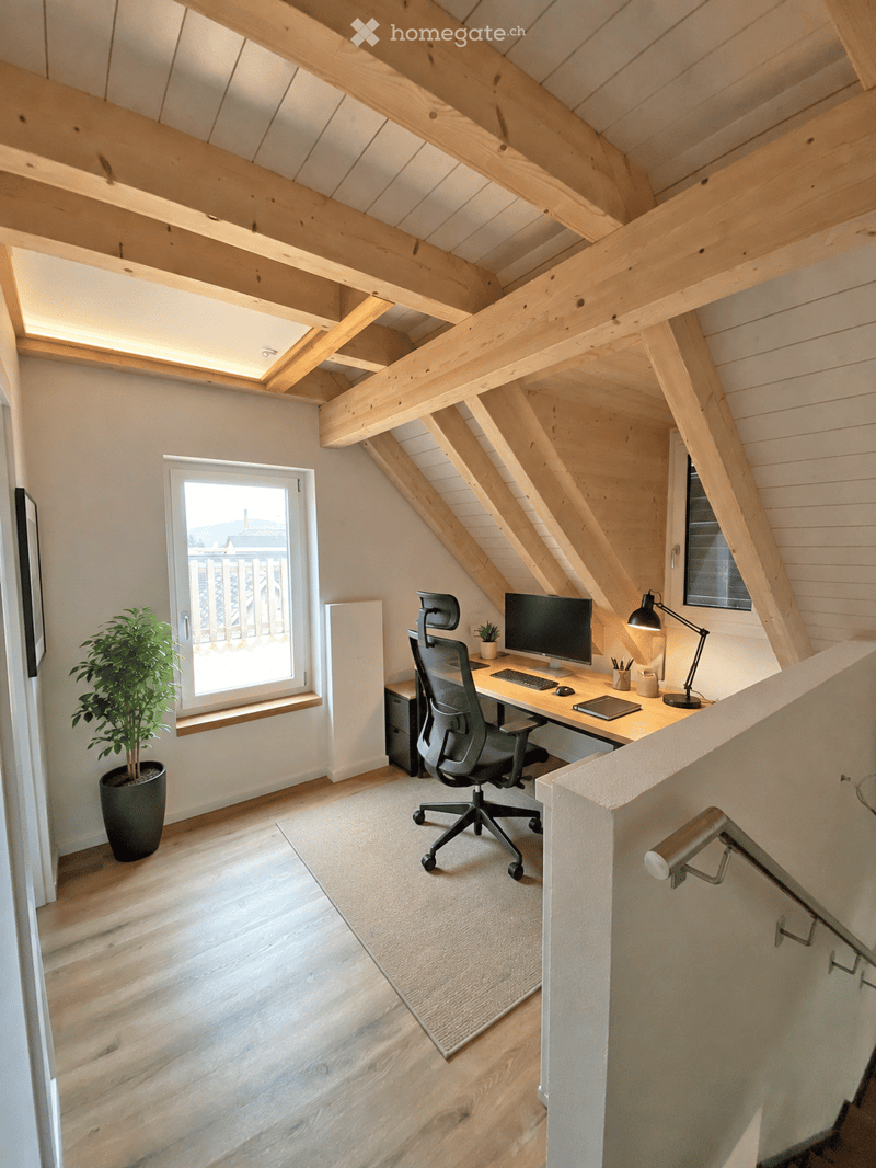 Modern attic office with exposed wooden beams, large window, desk, ergonomic chair, computer, and a small plant.