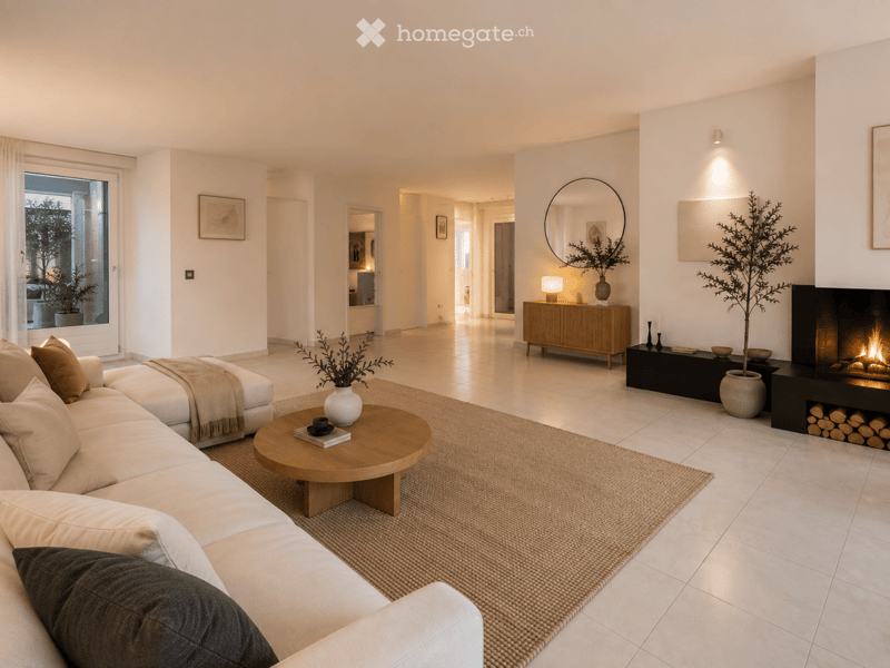 Modern living room with a white sofa, wooden coffee table, fireplace, side table, and decorative items.