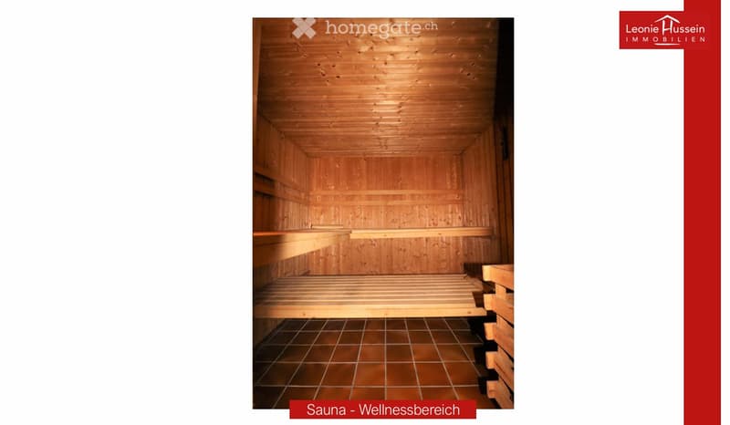 A wooden sauna with wooden benches and a tiled floor, part of a wellness area.
