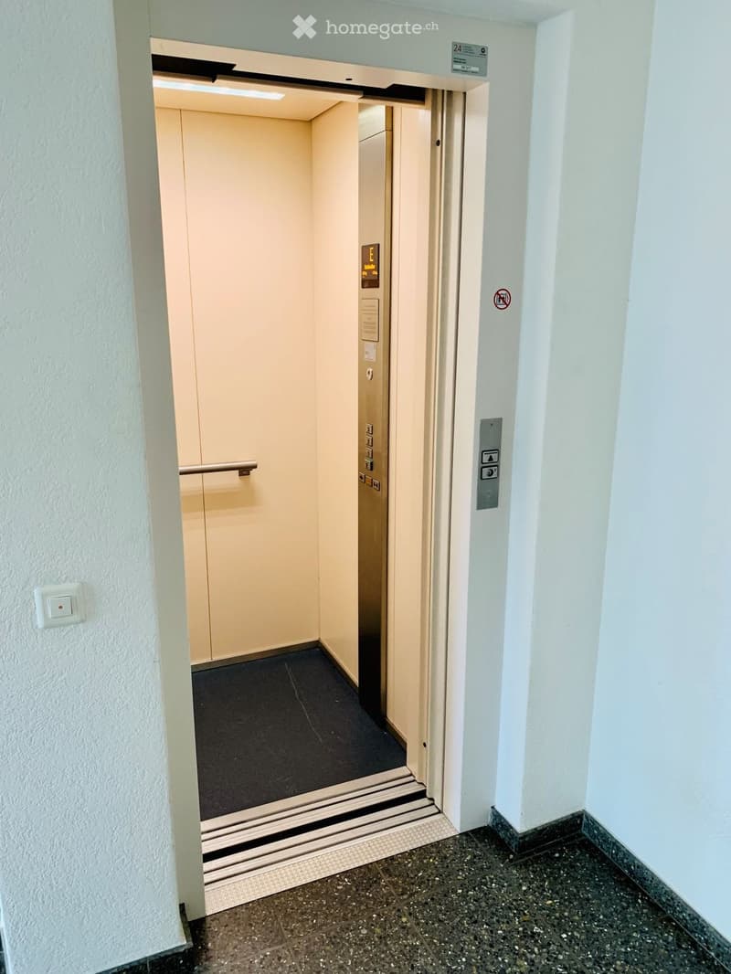 Corridor / Hallway. Hallway with an elevator door open, showing the elevator interior and control panel.