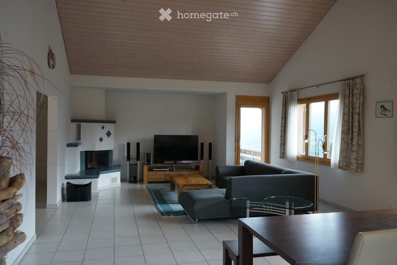 Modern living room with a fireplace, large windows, and a comfortable sofa set. The space features a wooden coffee table, a TV stand, and a sleek glass side table.