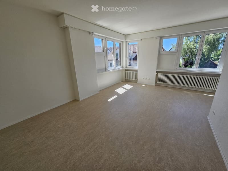 {"visible_features":[],"type":"Living room","description":"Spacious living room with large windows, white walls, and beige carpeted floor. The room appears to be empty and ready for furnishing."}