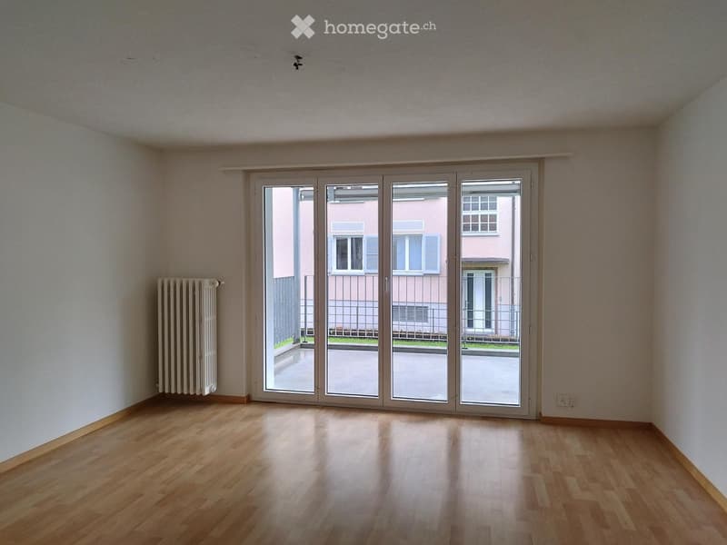 empty room, wooden floor, white walls, sliding glass doors, balcony, radiator