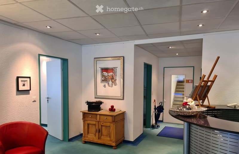 Lobby area with wooden cabinet, small bowl, closed door, framed picture, red chair