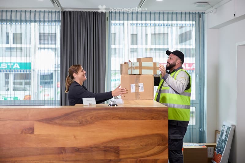 Wooden reception desk, curtains, window, building view, delivery boxes