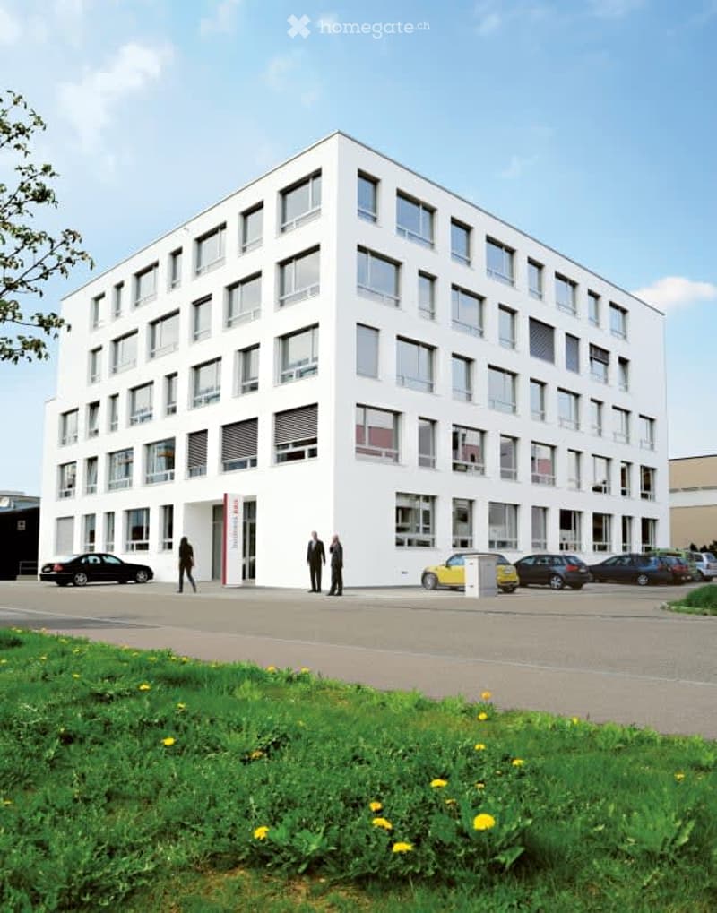 modern office building, white exterior, multiple floors, many windows, parking lot