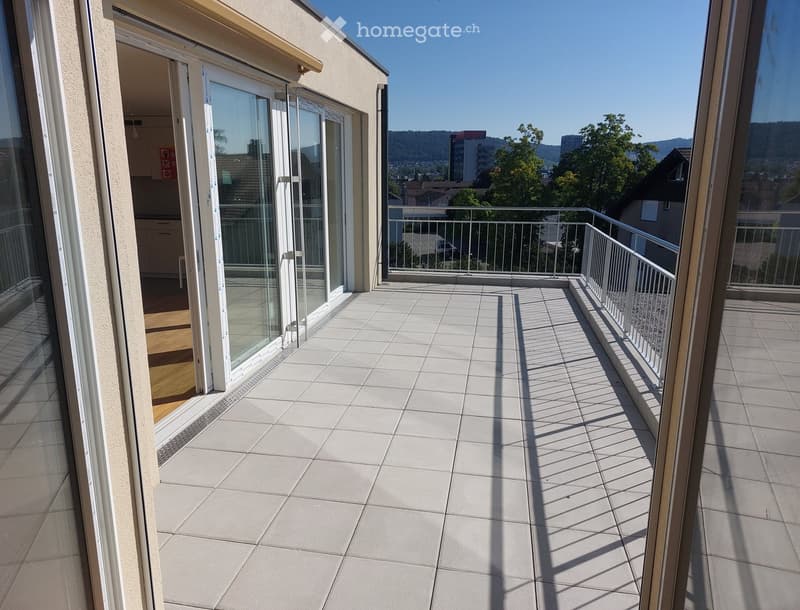 Balcony with tiled floor, metal railing, and open sliding glass doors leading to an interior space.