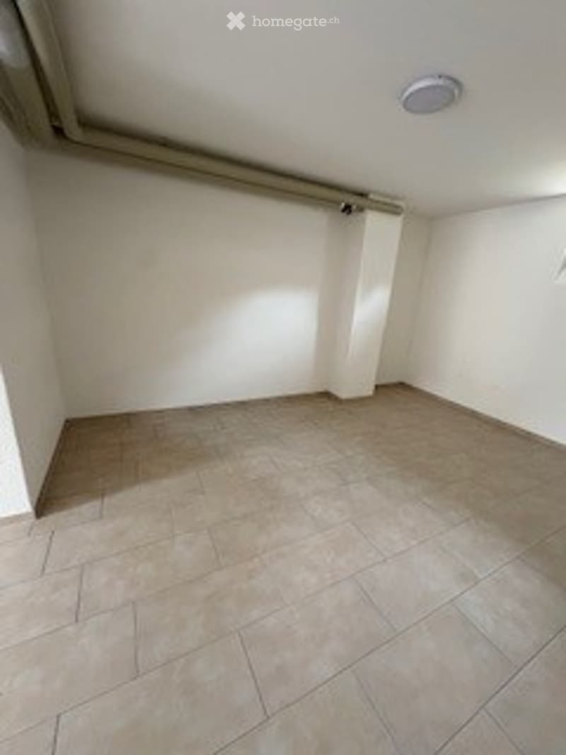 Empty room with tiled floor and white walls, no furniture or equipment.