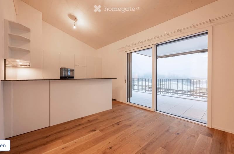 Modern kitchen with white cabinets, wooden flooring, and a large sliding glass door leading to a balcony.