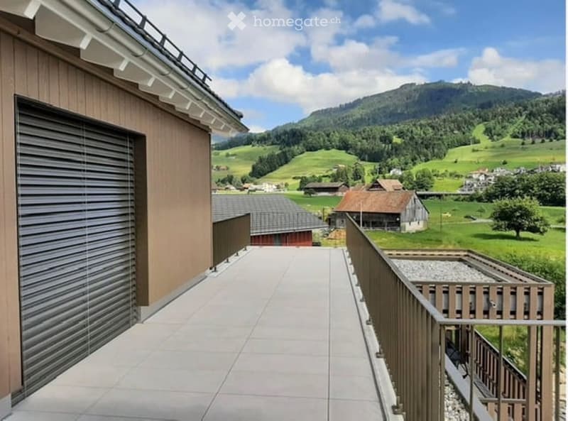 Balcony with tiled flooring, wooden railing, and scenic mountain view.