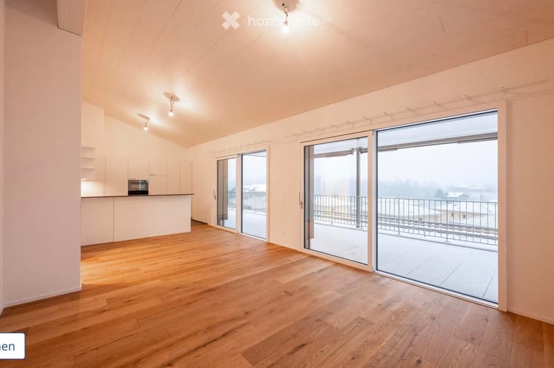 Empty room with wooden flooring, white walls, and large glass sliding doors leading to a balcony.