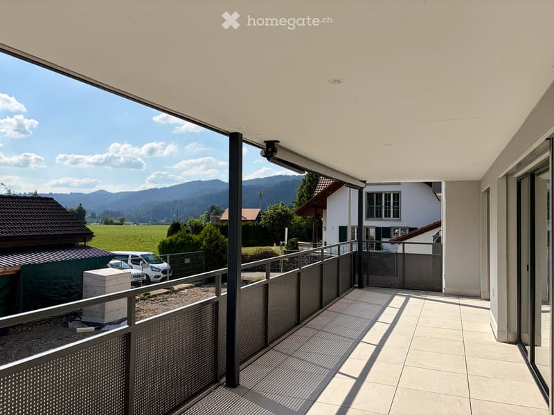 Balcony with modern railing, tiled floor, and scenic mountain view in the background.