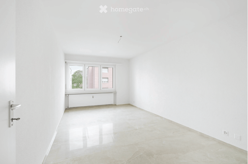 Empty room with white walls, tiled floor, large window, and door.