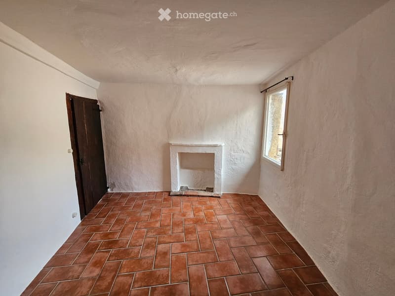 Empty room, fireplace, wooden door, window, white walls, red tile flooring