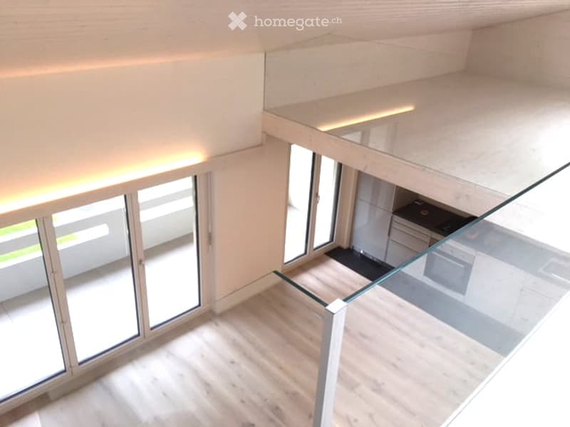 Open-plan floor plan with a raised ground floor, large windows, and a modern kitchen area visible below.