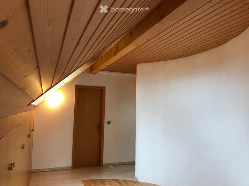 Empty hallway with wooden ceiling, tiled floor, and a single wooden door leading to another room.