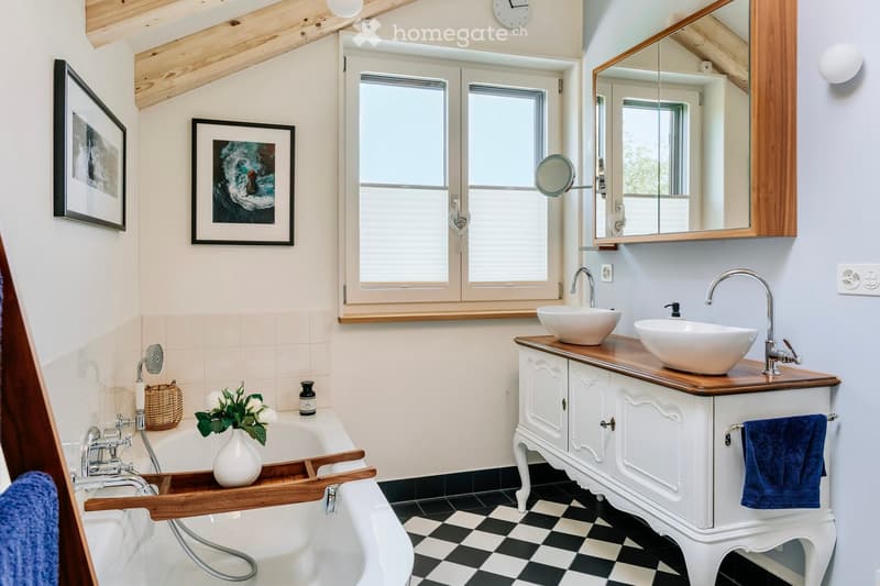 white bathtub, sink, wooden cabinet, framed artwork, tiled walls, wooden ceiling