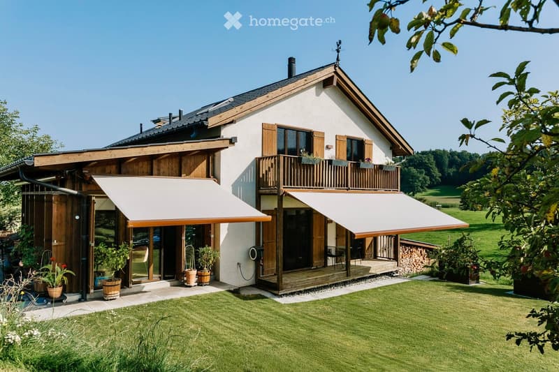 2 story house, wooden and white exterior, retractable awnings, wooden balcony, large lawn, potted plants