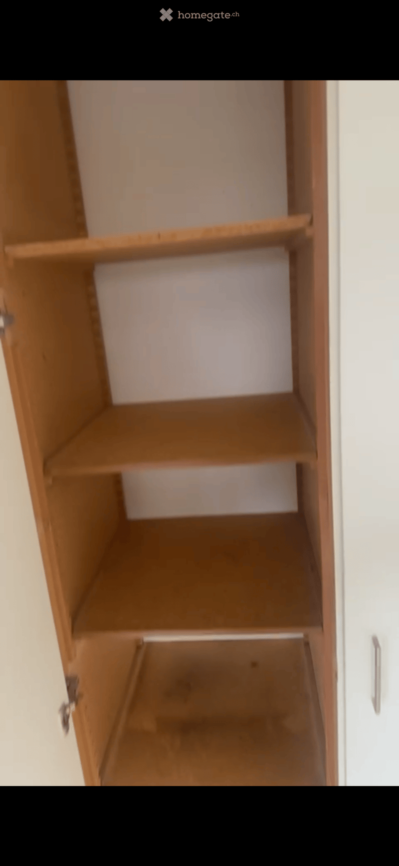 Empty wooden closet with multiple shelves and a bottom drawer, no items inside.
