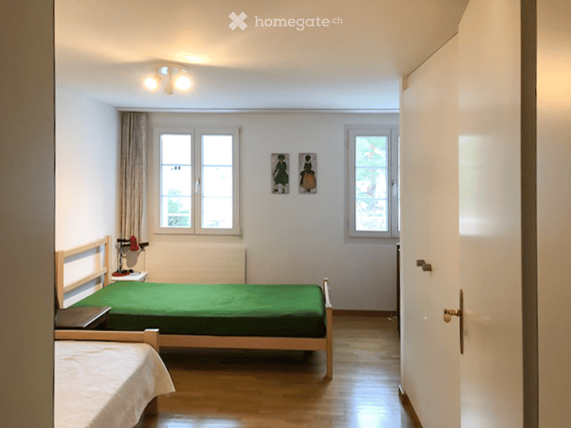 Two single beds, lamp, windows, radiator, flooring