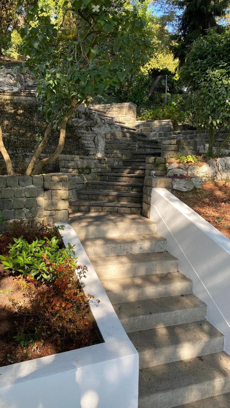 concrete stairs leading to upper level with stone walls