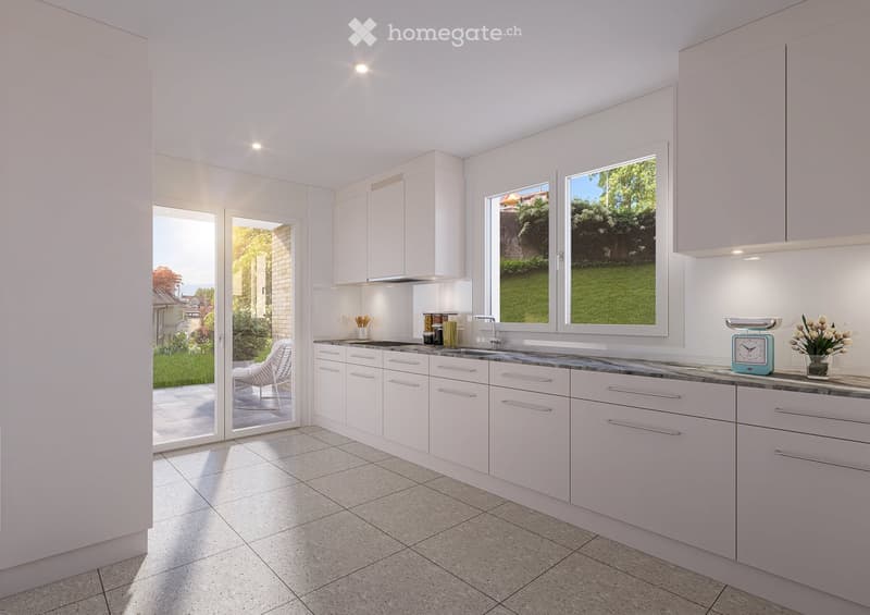 Modern white kitchen with sleek cabinets, granite countertop, and large windows overlooking a garden. Features a sink, faucet, clock, vase with flowers, and a white chair visible through the open sliding doors.