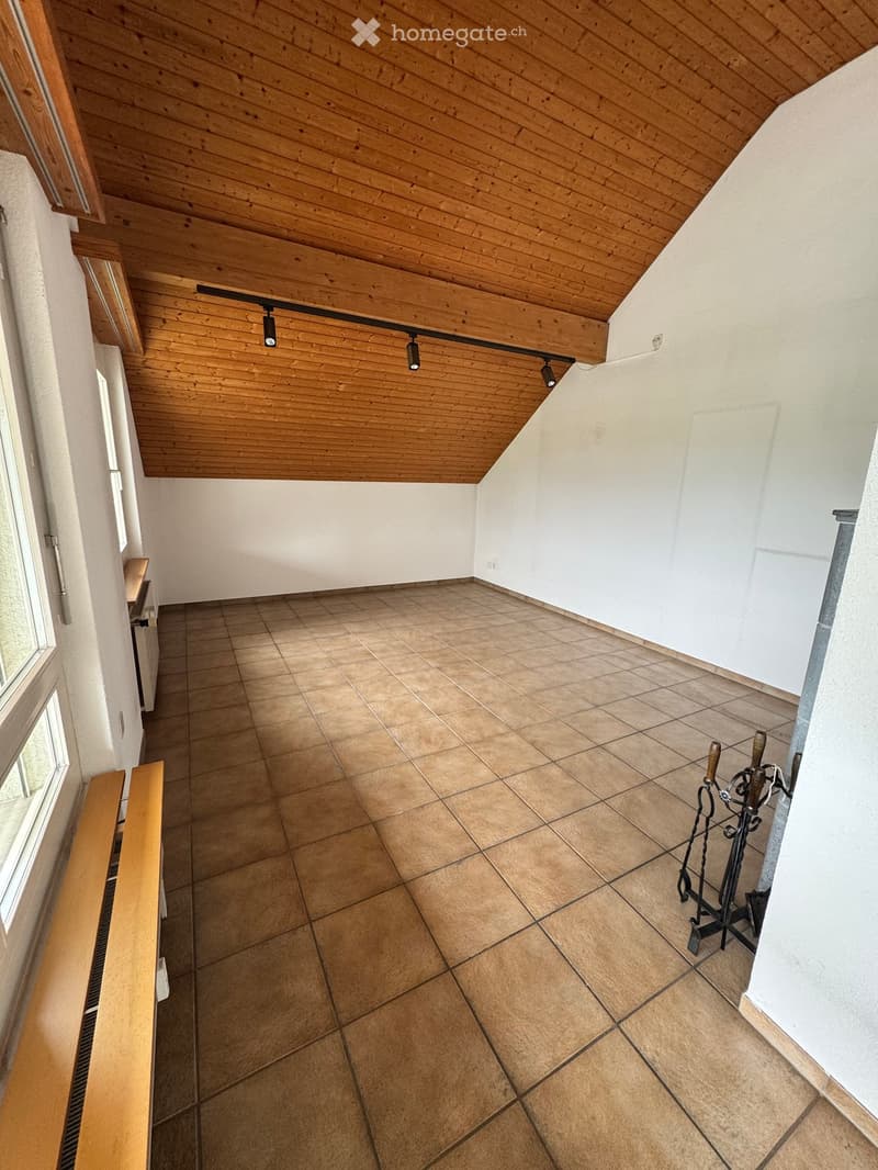 Empty hallway with tiled floor, wooden ceiling, white walls, and a small bench near the window.