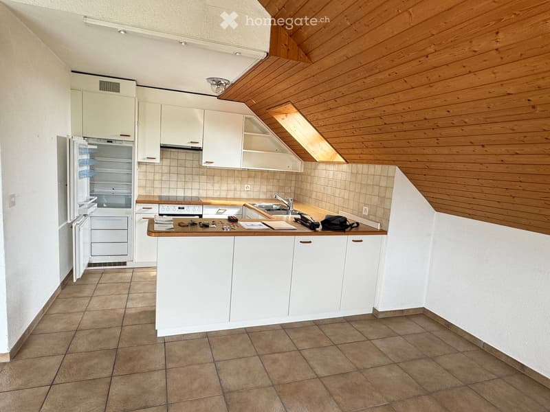 Modern kitchen with white cabinets, wooden countertop, refrigerator, oven, sink, and various items on the counter.
