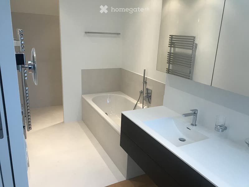 Bathroom: bathtub, sink, mirror, shower head, towel rack, flooring