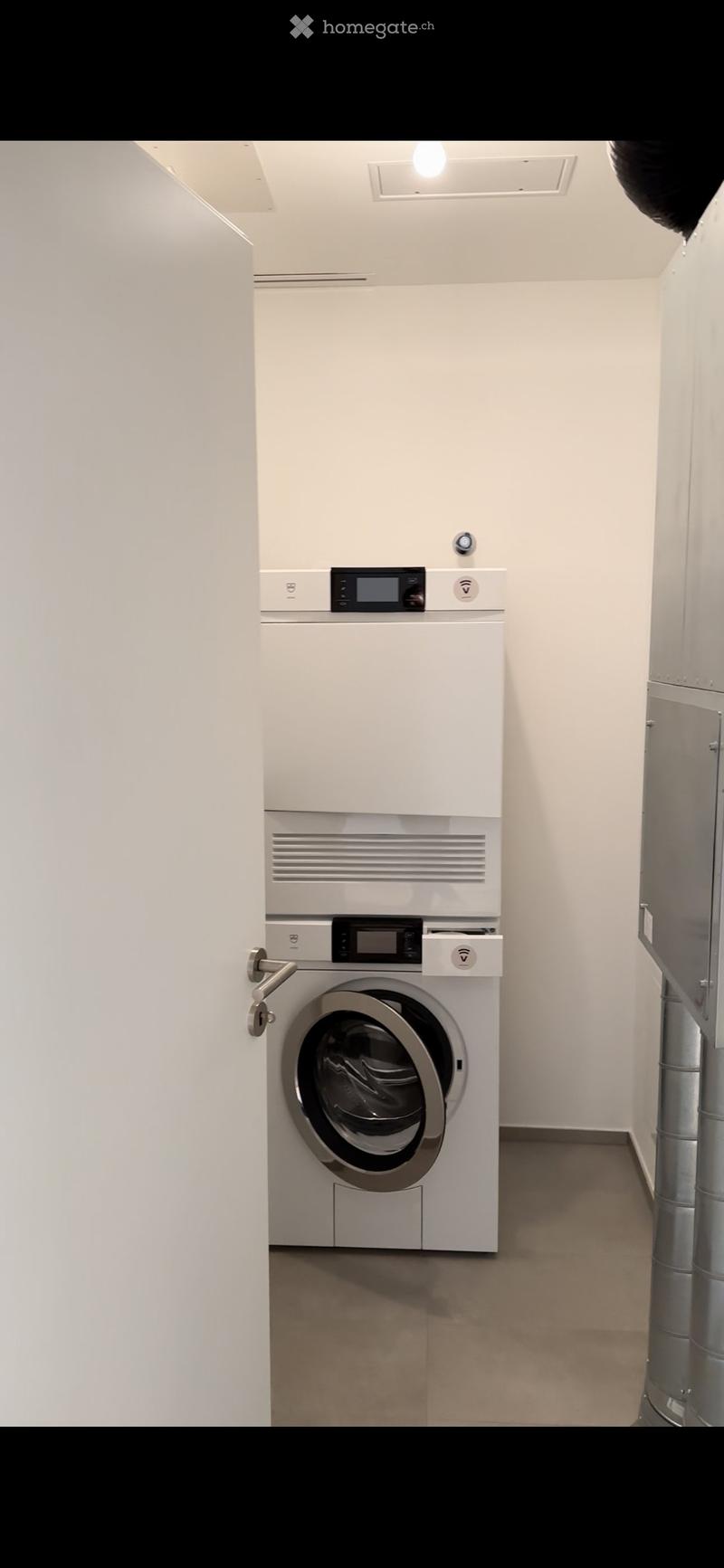 Modern, minimalist laundry room with a white washing machine and dryer unit, sleek design, and neutral tones.