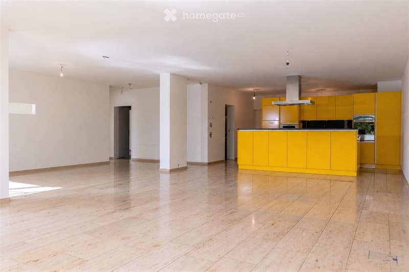 Empty kitchen area with yellow cabinets, stainless steel range hood, and tiled floor. No furniture or appliances are present.